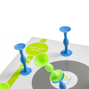 Blue and green suction-cup game pieces on a white board with a circular target and the words 'INSTANT WIN!'